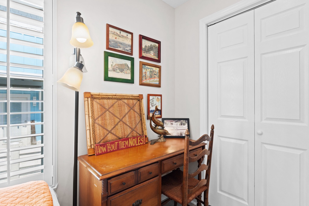 Your charming workspace features vintage charm with a classic wooden desk, nautical artwork, and warm lighting for productive mornings.