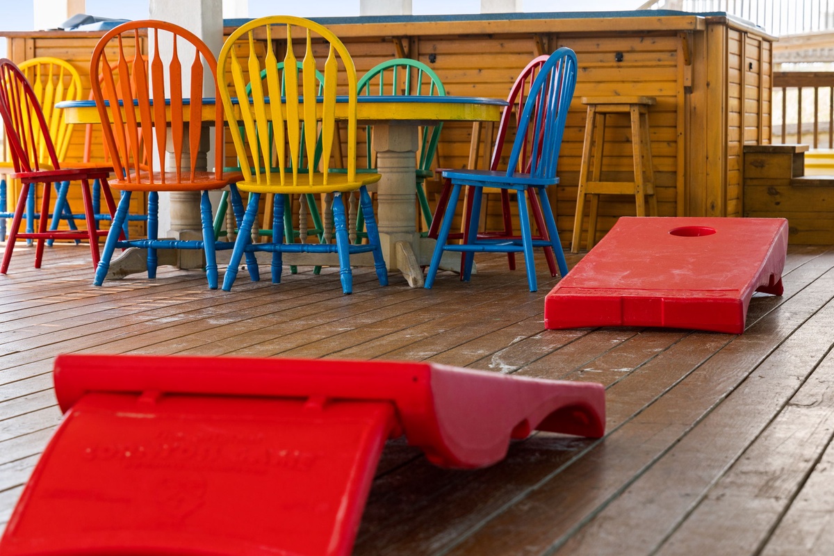 Gather around for games and laughter at your vibrant outdoor dining area, complete with colorful seating and cornhole boards for endless entertainment on the spacious deck.