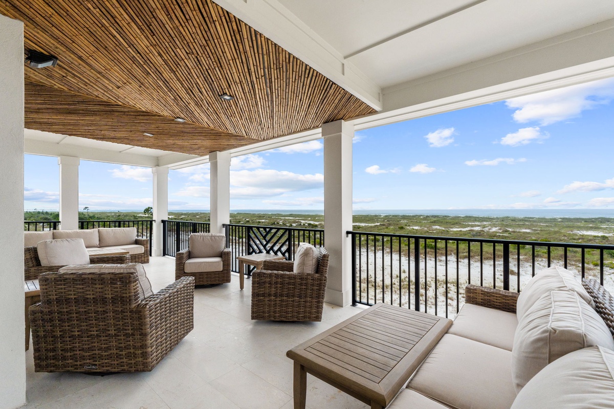 Sweeping coastal vistas stretch before you from this covered terrace. Sink into plush outdoor seating beneath a striking wooden-slatted ceiling and unwind in your private sanctuary.