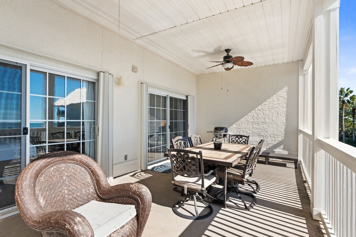 Your covered balcony offers the perfect spot for outdoor dining with comfortable seating and gentle ceiling fan breezes.