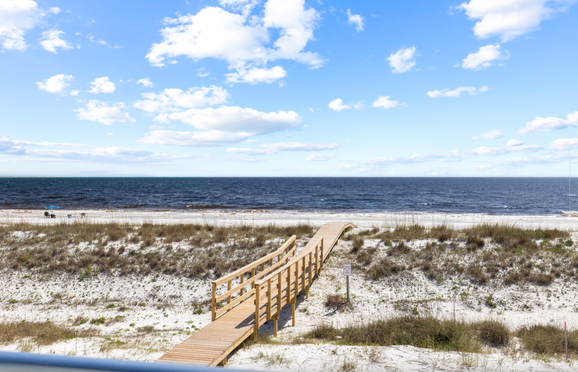Pristine beachfront location with wooden boardwalk leading to white sand shores and endless ocean views.