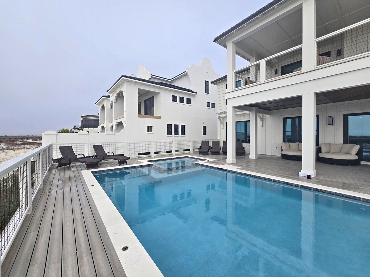 Modern beachfront villa featuring pristine swimming pool and elegant white architecture.