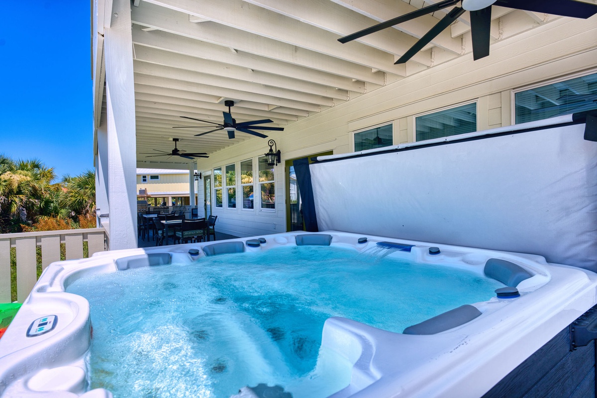 Slip into warm, bubbling water under a covered patio with ceiling fans and glimpses of palm trees—your private escape for ultimate relaxation.