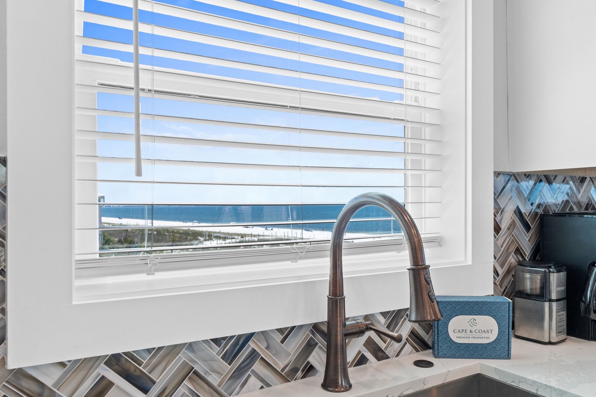 Step into your kitchen and gaze at stunning coastal views through your window—ocean breezes and sandy shores await just beyond the elegant backsplash.