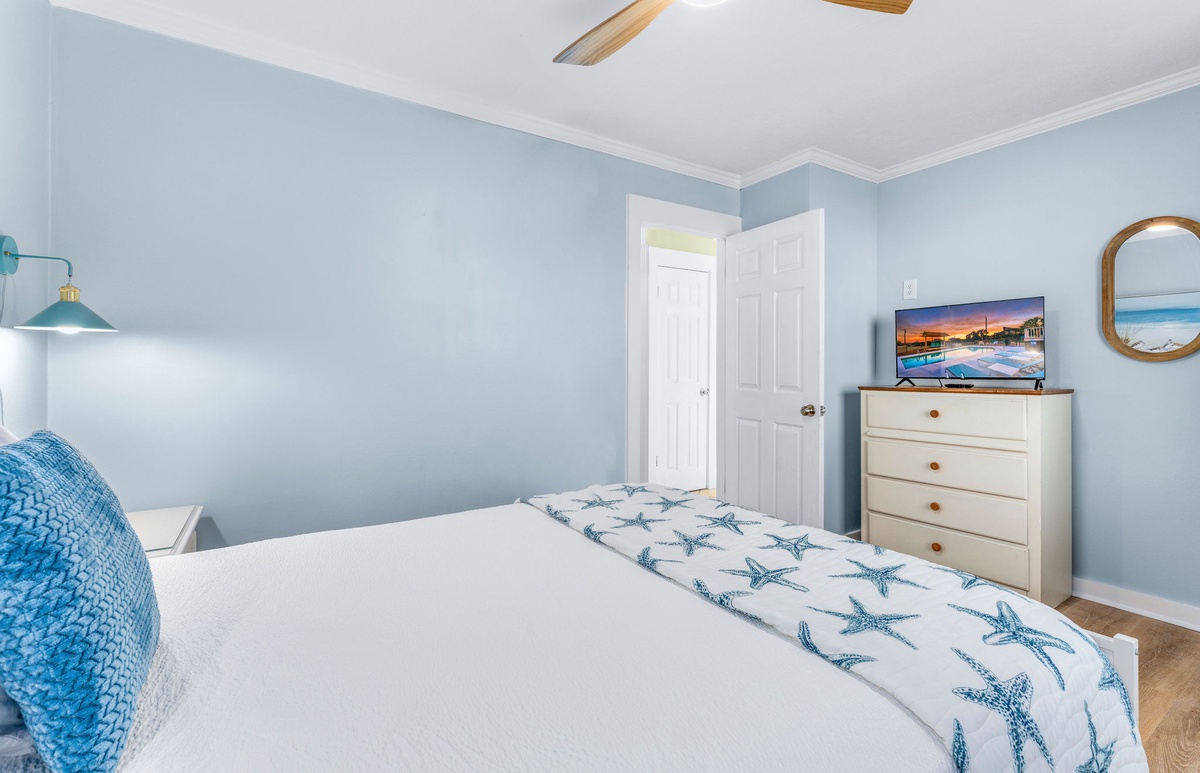 Drift off in this peaceful blue bedroom where starfish linens and ocean breezes from your ceiling fan create the perfect coastal retreat.