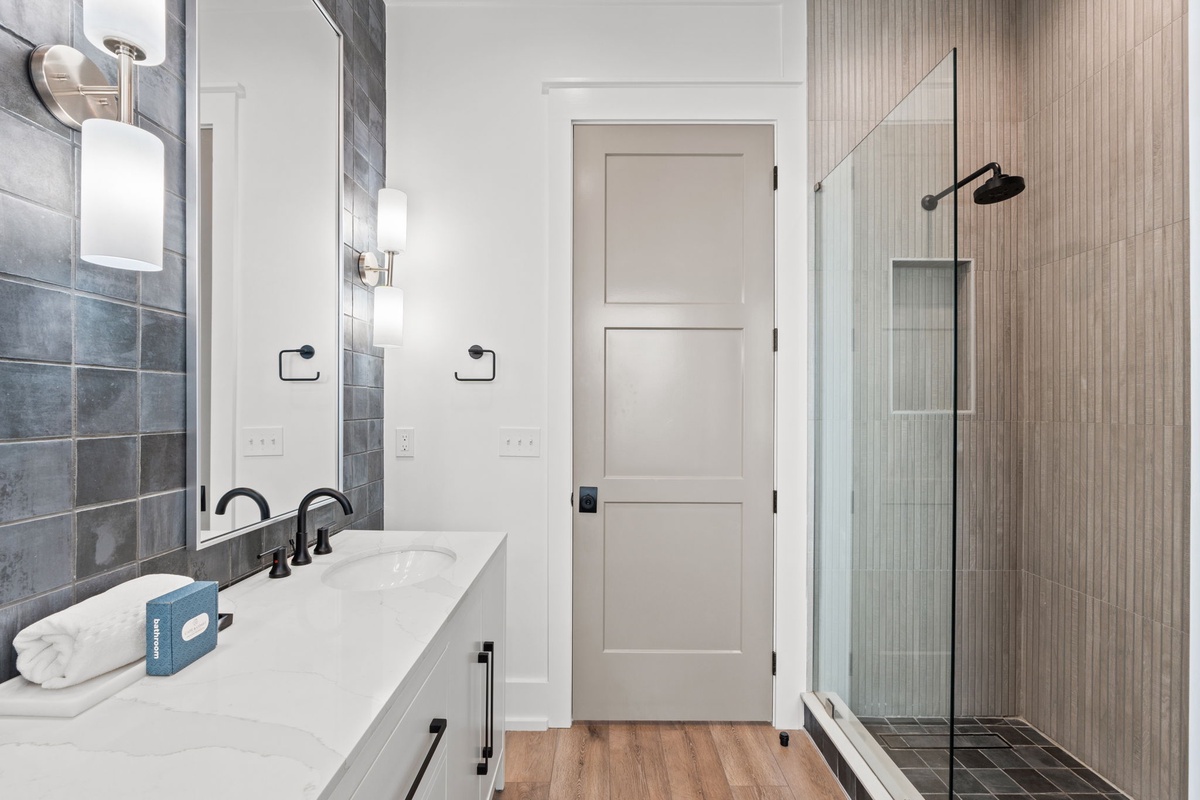 Refresh in your spa-like bathroom with marble counters, modern fixtures, and a spacious glass shower with sleek tile.