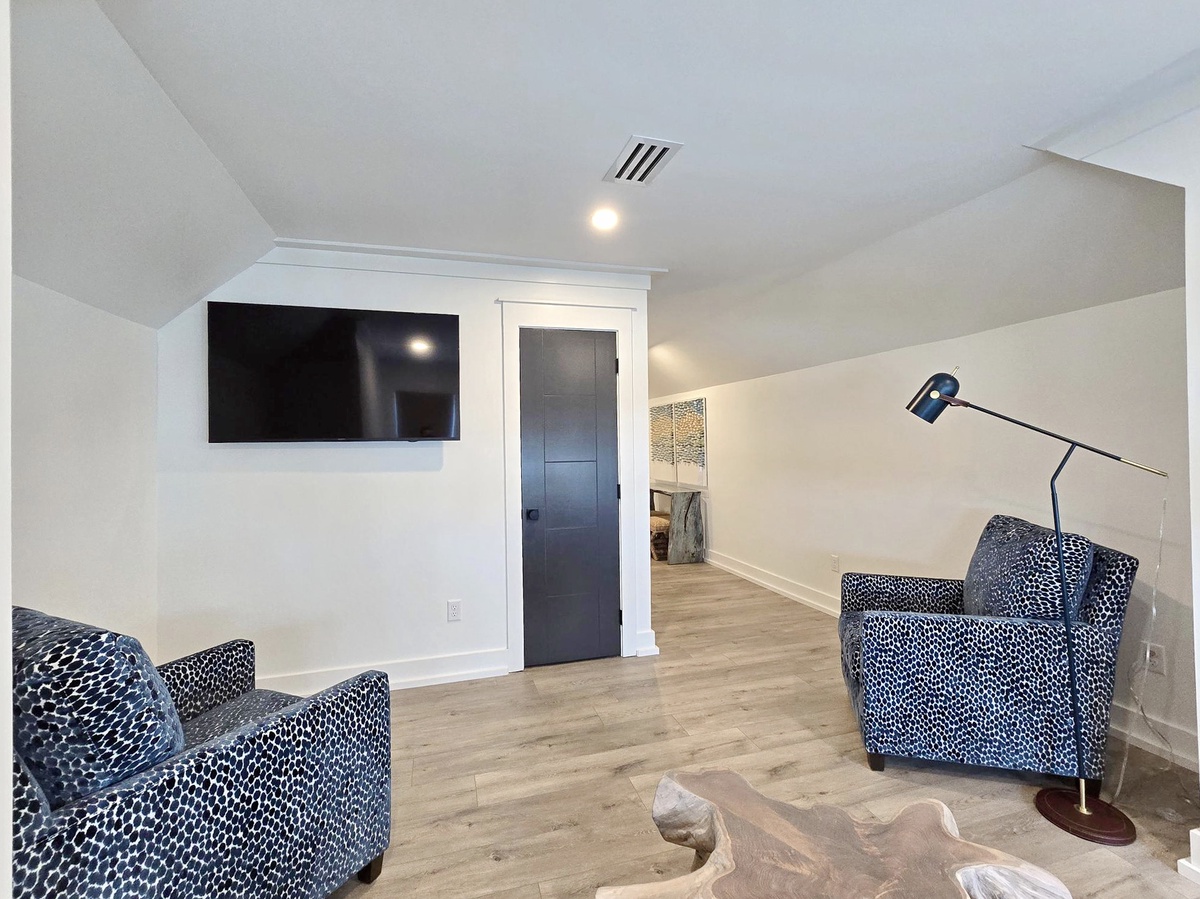 Unwind in your private upstairs retreat with stylish spotted chairs and smart TV for cozy movie nights.