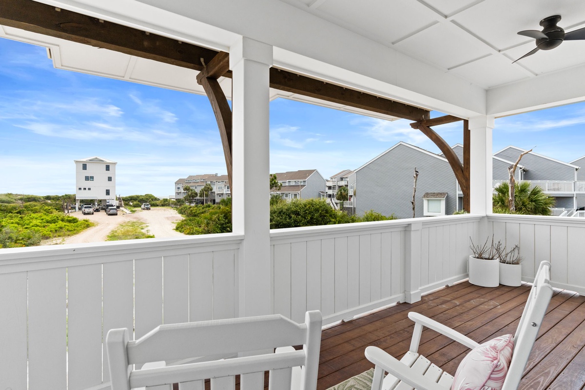 A covered porch with coastal charm—relax in your private seating area while enjoying gentle breezes and peaceful views of the surrounding beach neighborhood.
