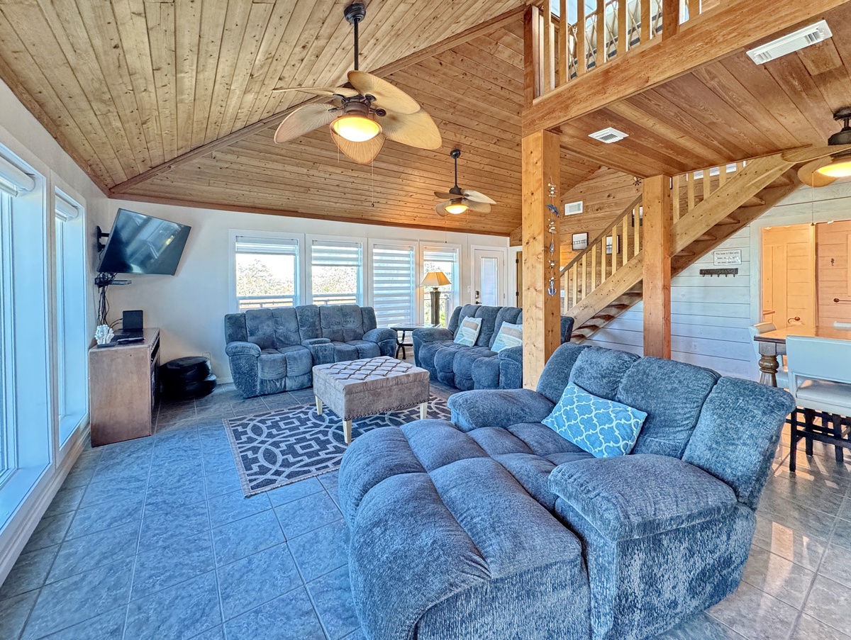 Sink into plush recliners beneath soaring wood beams while gentle fans circulate cool air through your spacious retreat.