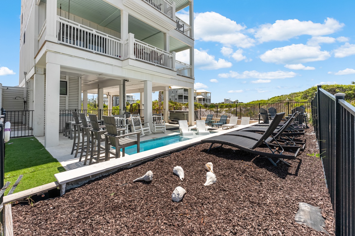 Your private paradise awaits with a sparkling pool, lounge chairs for soaking up the sun, and a spacious covered patio perfect for relaxing.
