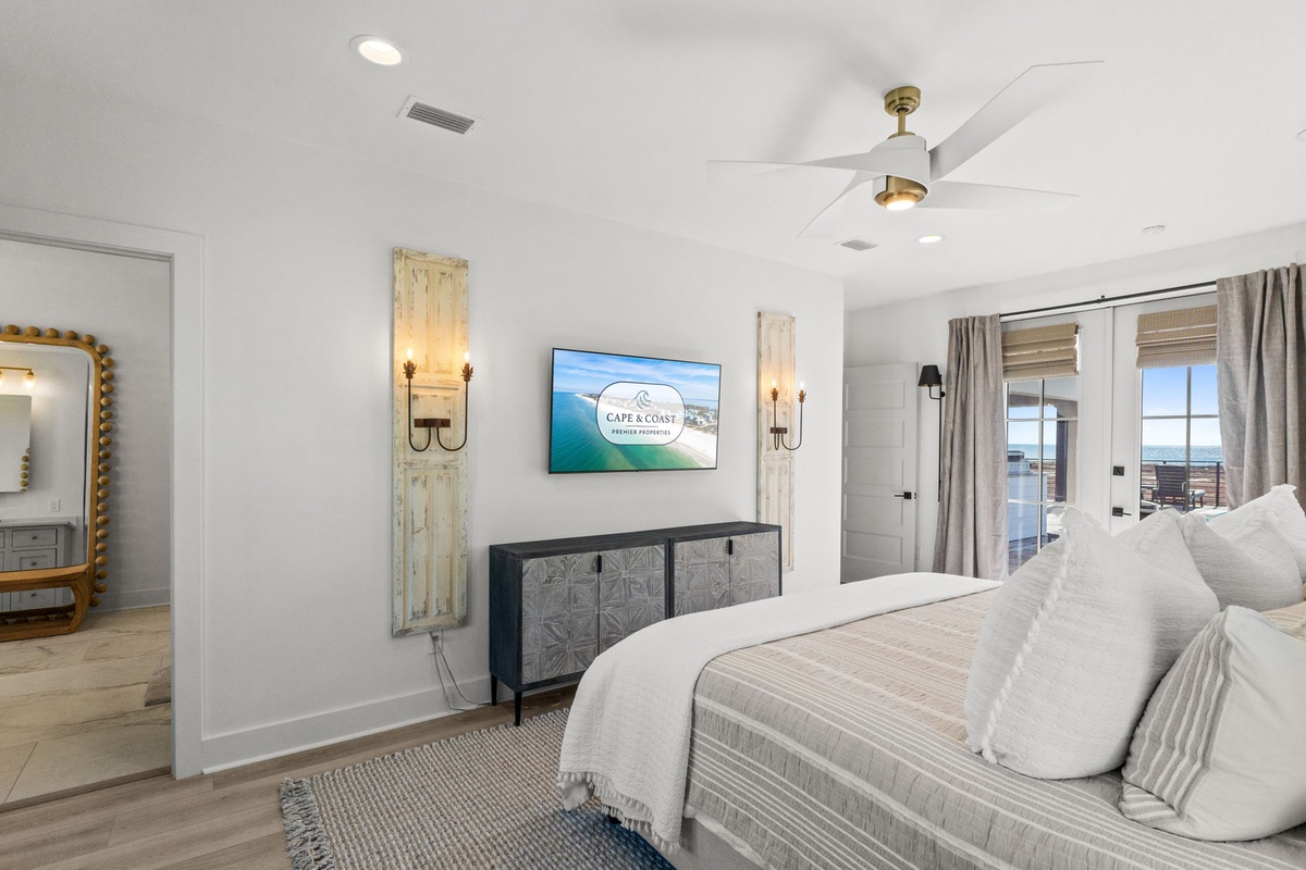 Sink into your coastal retreat's master bedroom, where modern comfort meets beachside elegance with ocean views and soothing décor.