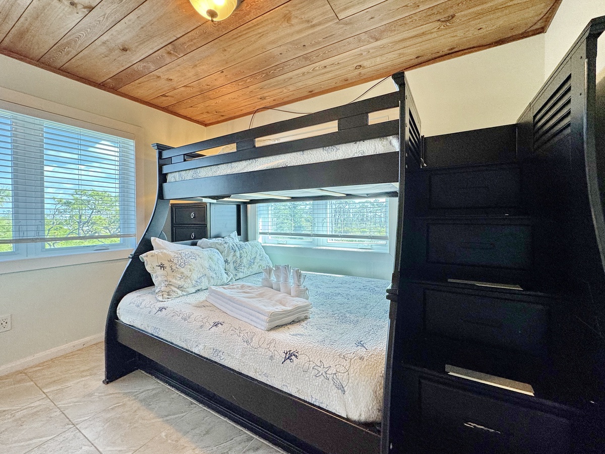 Rest in this charming bunk bed room with rustic wood ceiling and natural light streaming through your window.