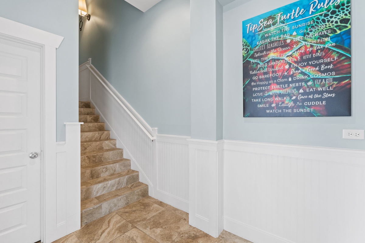 Step into a bright coastal escape where beach-inspired art and soothing tones welcome you at the entrance, setting the tone for your seaside adventure.
