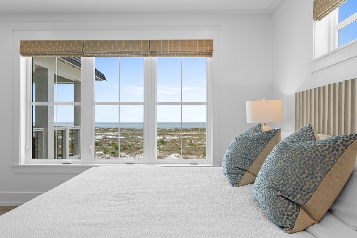 Wake up to sweeping coastal views from this serene bedroom, where soft linens and ocean breezes invite you to unwind and recharge in peaceful comfort.