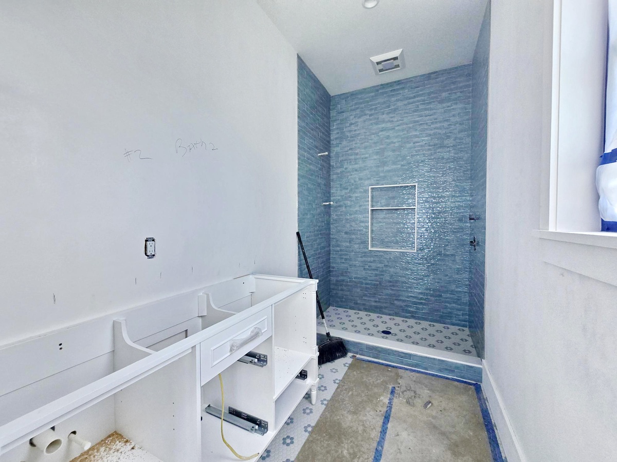 This modern bathroom features beautiful blue glass tile work and a spacious walk-in shower where you can rinse off after a day of adventure.