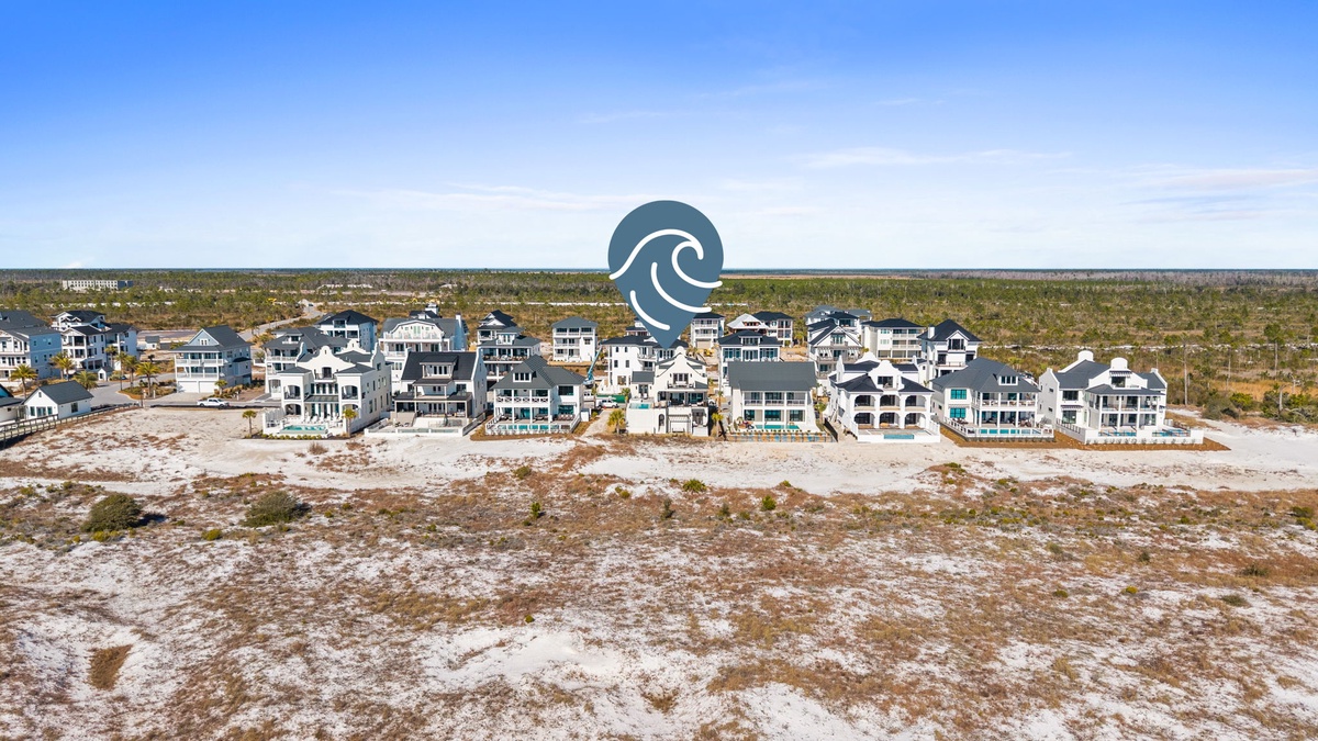 Beachfront vacation homes line the pristine coastline, offering direct beach access and stunning ocean views.