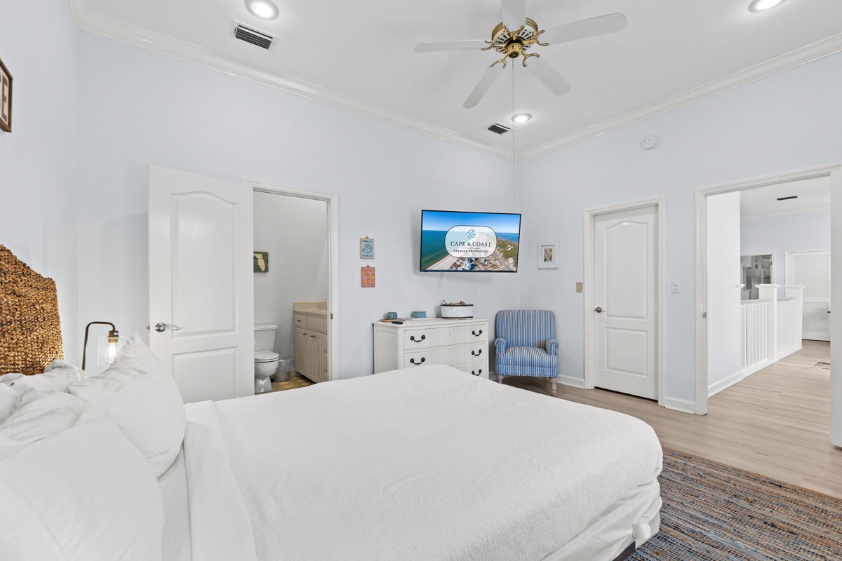 Relax in your spacious master bedroom with coastal charm, featuring a plush king bed, private en-suite, and smart TV for cozy evenings.