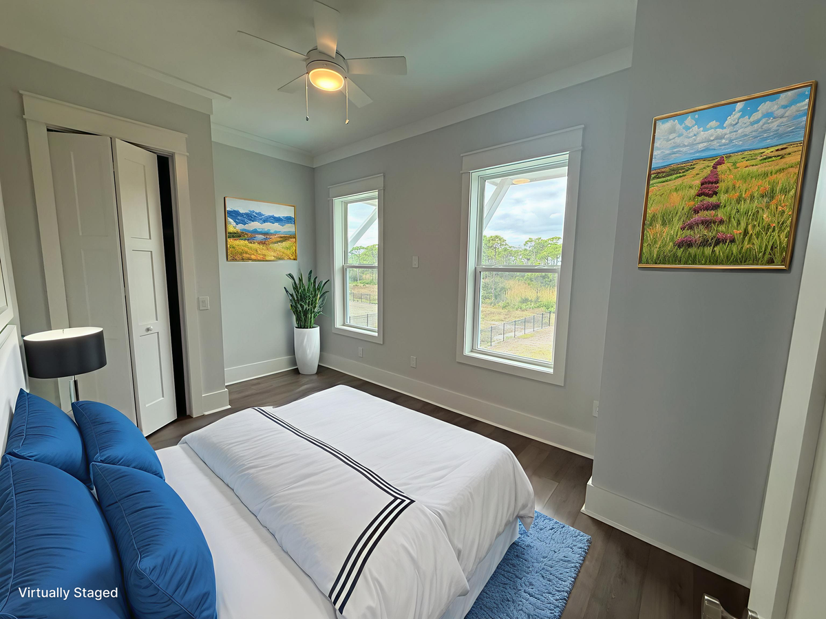 Your bright bedroom features crisp linens and nature artwork, with windows overlooking peaceful countryside views.