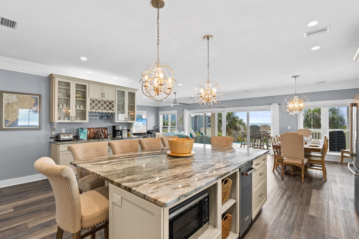 Gather with loved ones in this stunning open-concept kitchen and dining space, where elegant pendant lighting illuminates your culinary adventures and memorable meals together.