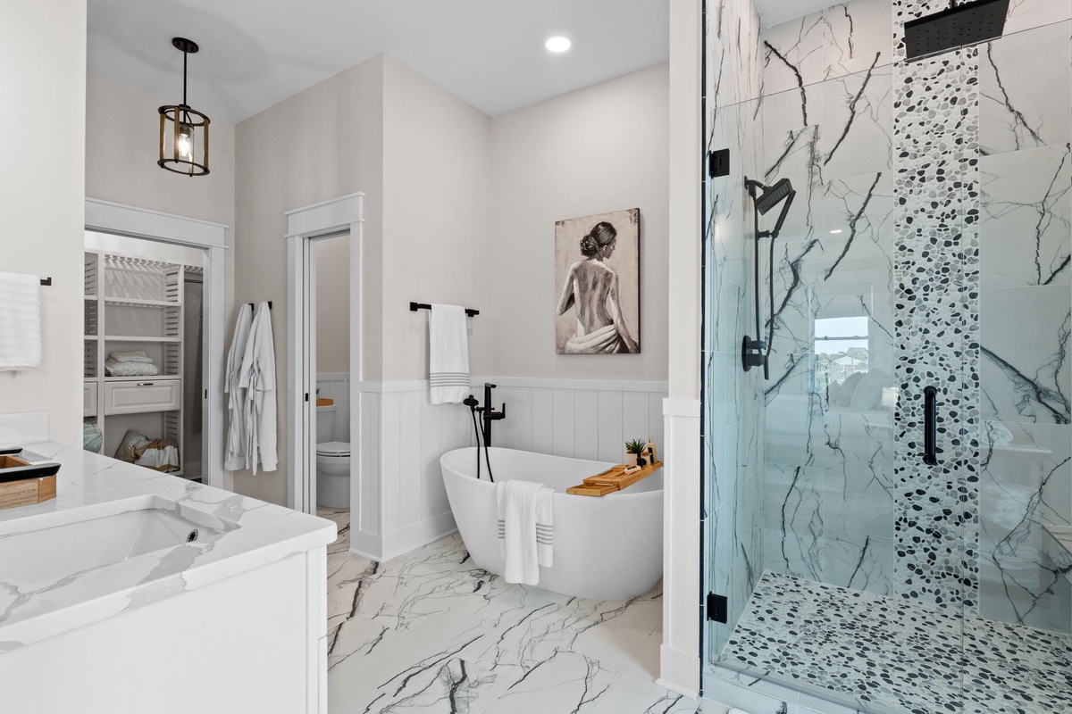 Unwind in your luxurious bathroom featuring a freestanding soaking tub, walk-in shower with rainfall head, and elegant marble finishes. Plush robes and soft towels await you.