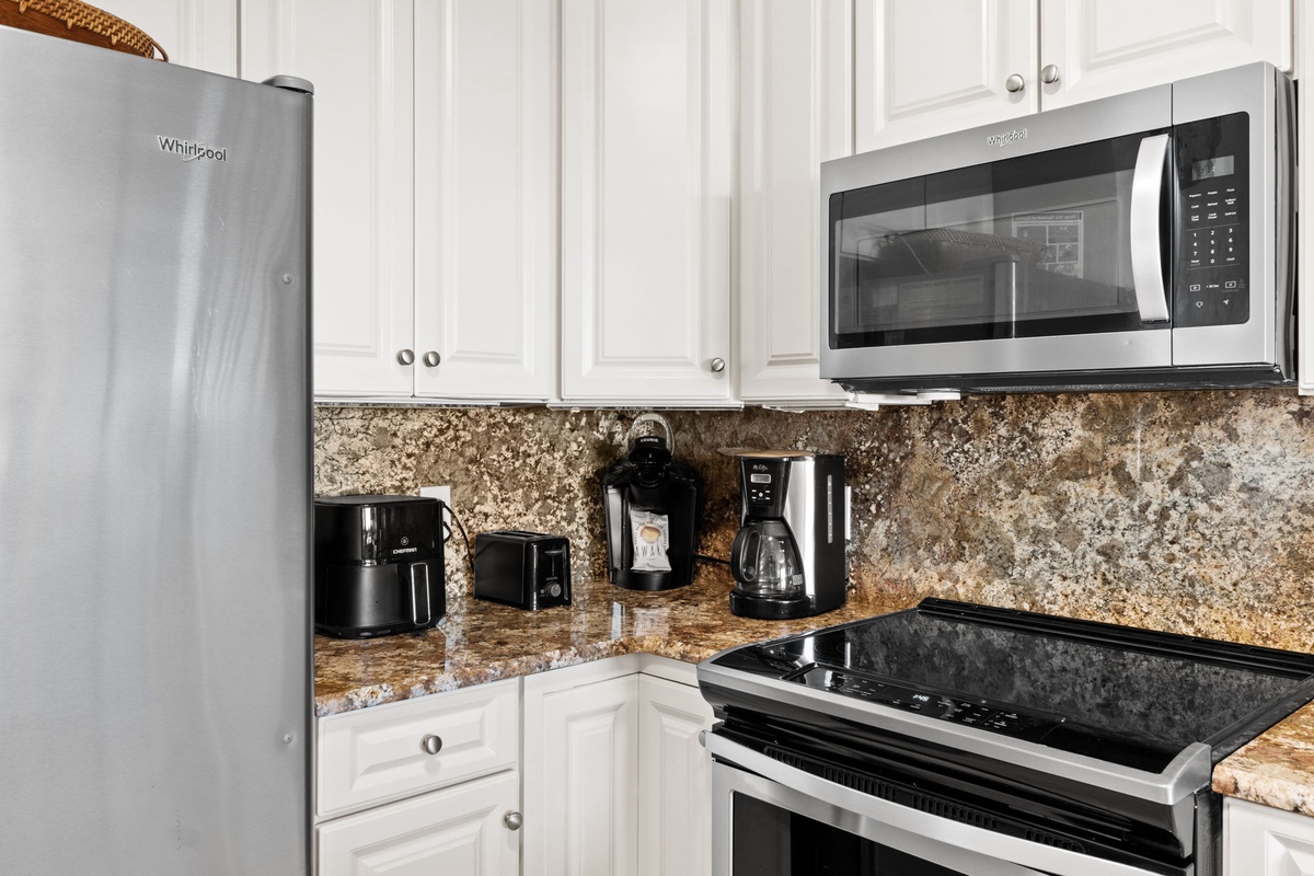 Your fully equipped kitchen features granite counters, stainless appliances, and coffee station for delicious home-cooked meals.