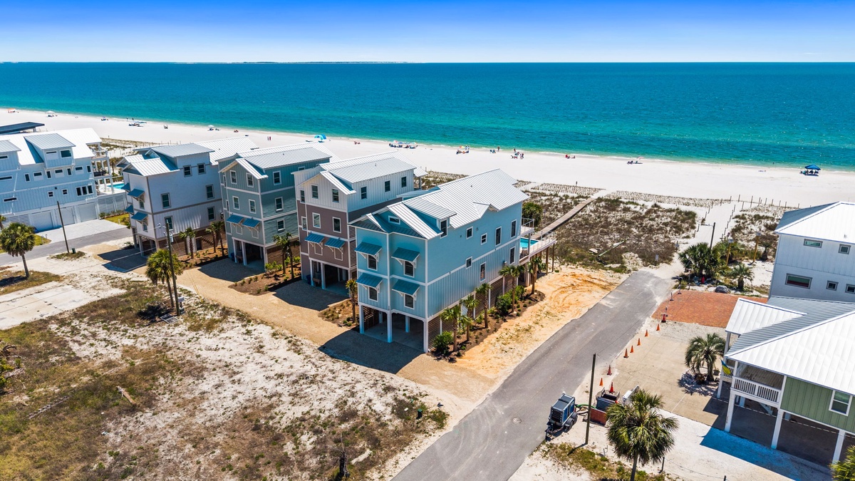 Beachfront property located steps from pristine white sand and crystal-clear turquoise waters, part of a charming coastal community with palm-lined streets and stunning Gulf views.