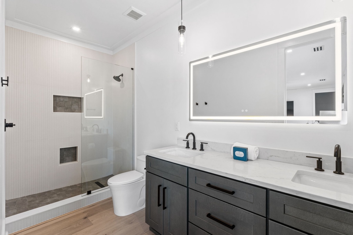 Your beautifully appointed bathroom features a spacious walk-in shower, dual vanity with elegant lighting, and modern fixtures that blend style with everyday comfort.