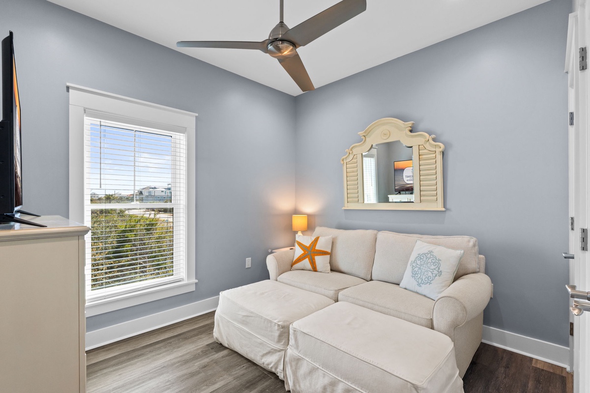 Sink into your cozy reading nook with plush seating, coastal charm, and gentle breezes from your ceiling fan.
