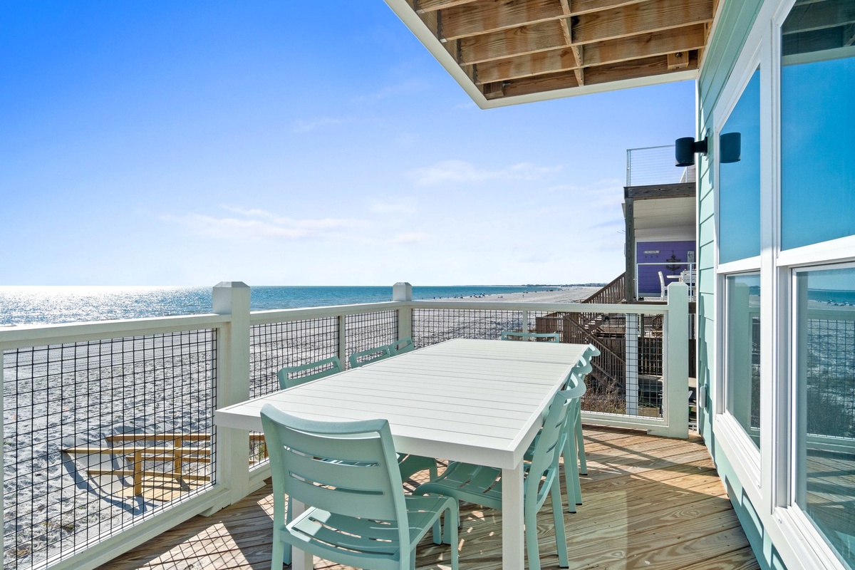 Dine al fresco on your private oceanfront deck, where turquoise chairs and endless sea views create the perfect setting for morning coffee or sunset meals.