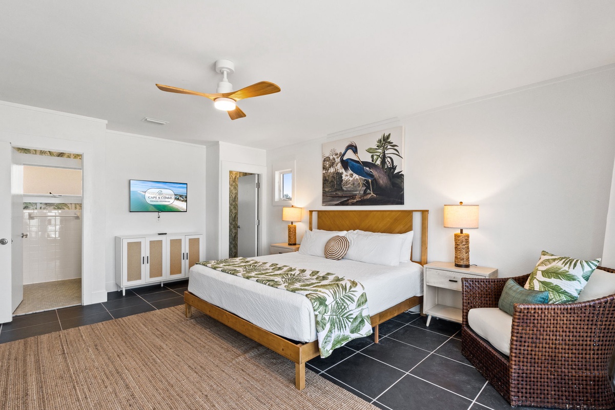 Your bright, spacious bedroom features tropical-inspired decor, a ceiling fan for comfort, and a cozy sitting area where you can unwind after exploring nearby attractions.