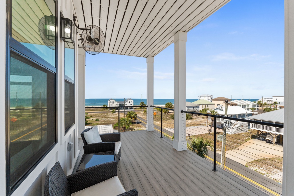 Your covered balcony offers comfortable seating with stunning ocean views and cooling fans for perfect seaside relaxation.