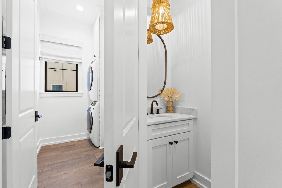 Your private powder room features elegant marble countertops and stylish woven lighting, with convenient laundry access just steps away.