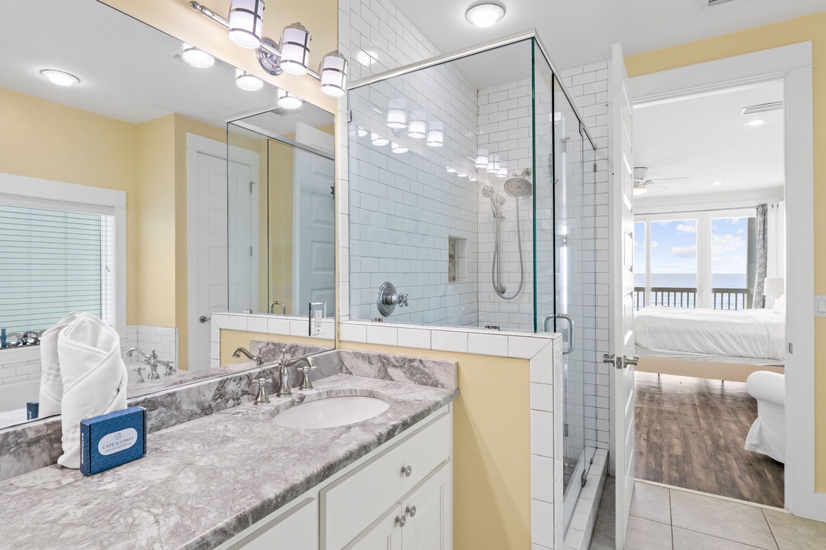 Your elegant bathroom features marble countertops, a spacious glass shower, and thoughtful amenities to refresh after your coastal adventures.