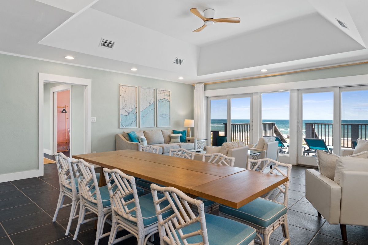Picture yourself gathering with loved ones in this bright, coastal living space where ocean breezes drift through open doors and waves frame every moment of your stay.