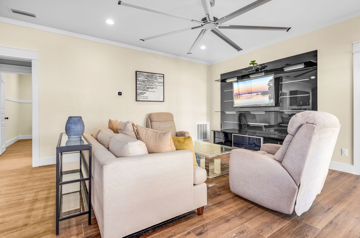 Sink into plush seating while enjoying your favorite shows on the large TV in this bright, airy living space with modern entertainment center.