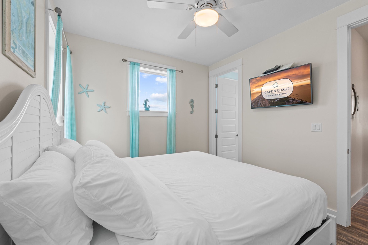 Drift off to sleep in this peaceful coastal-themed bedroom, where soft white linens and ocean accents create your perfect seaside retreat.