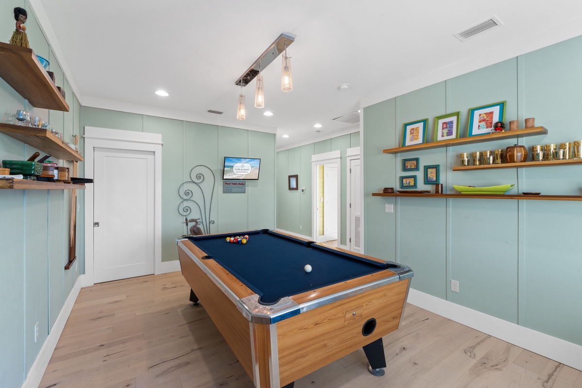 Challenge friends to billiards in your stylish game room, where soft green walls and warm wood shelves create the perfect atmosphere for friendly competition.