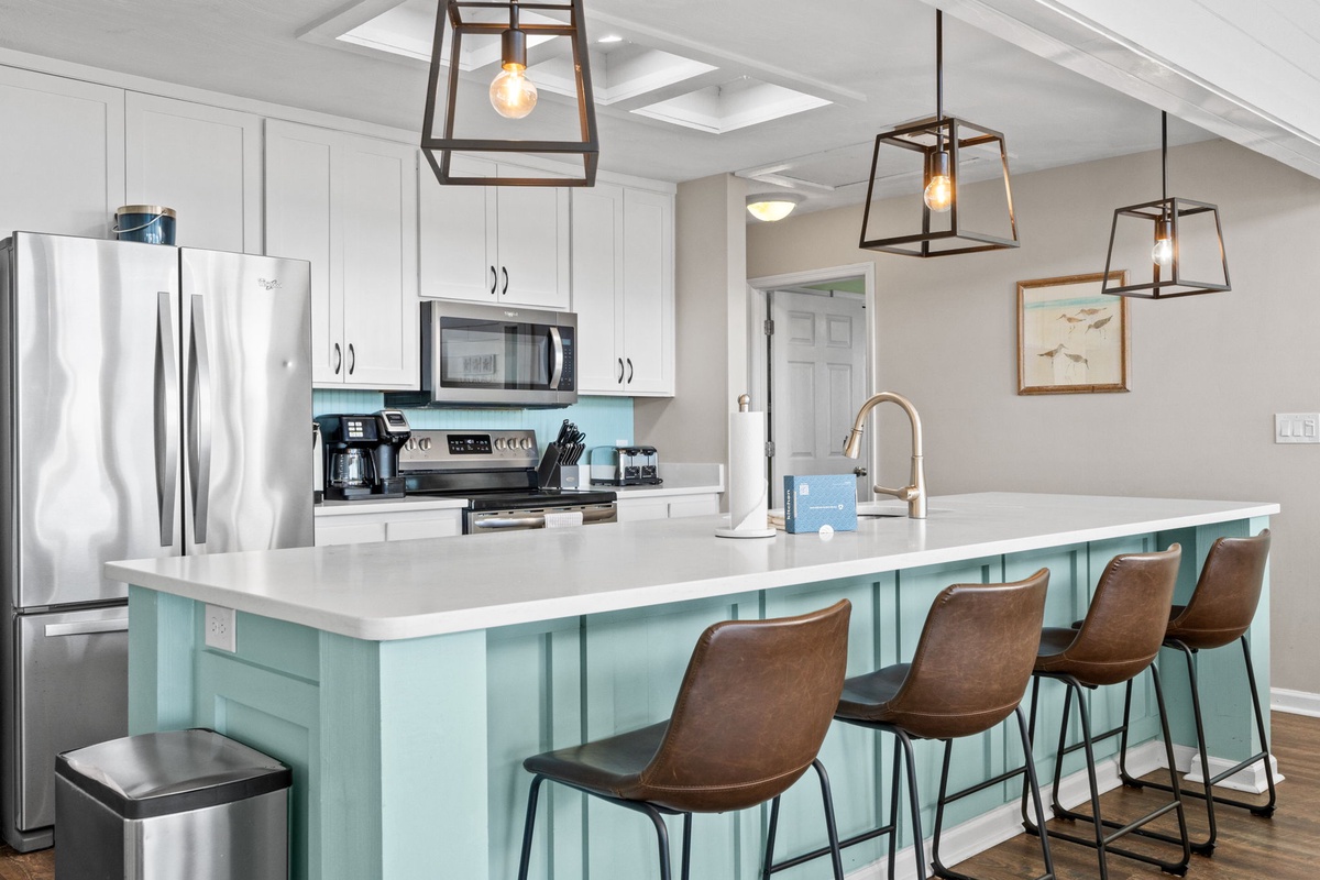 Your spacious kitchen features modern stainless appliances, sleek quartz counters, and a charming turquoise island with comfortable seating for memorable meals together.