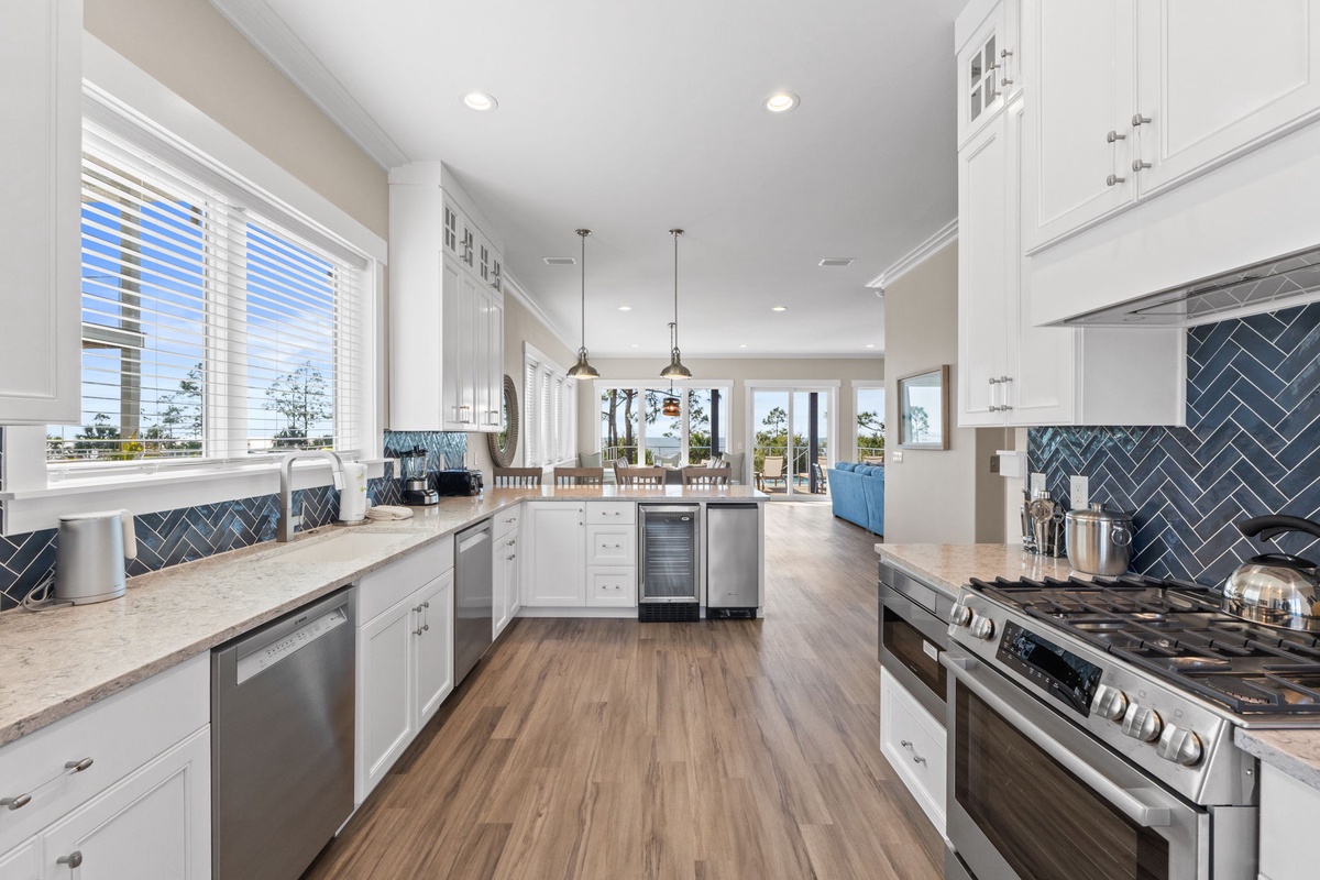 Your spacious white kitchen features stunning blue herringbone backsplash, premium appliances, and flows seamlessly into bright living areas perfect for gatherings.