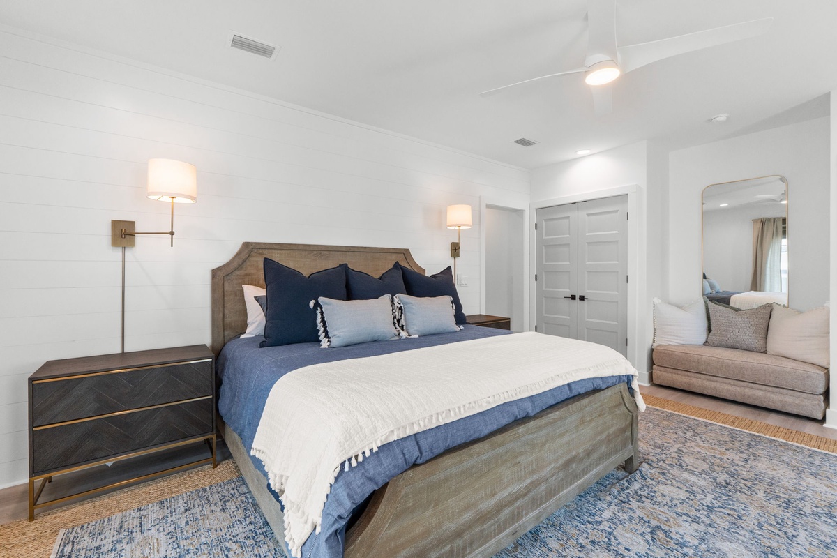 Sink into plush blue bedding and unwind in your reading nook, where soft lighting creates the perfect ambiance for peaceful evenings.