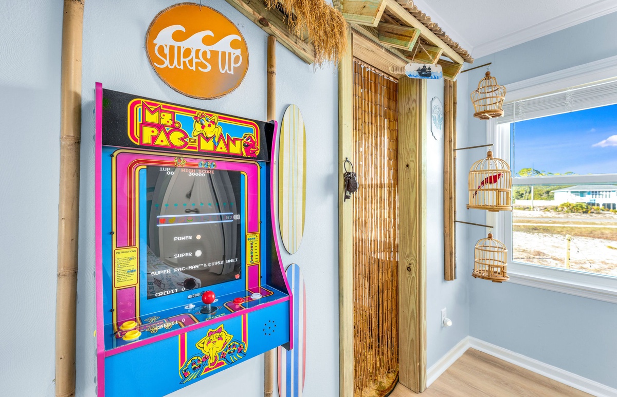 Challenge friends to classic arcade fun with Ms. Pac-Man in this vibrant beach-themed game room featuring surf-inspired decor.