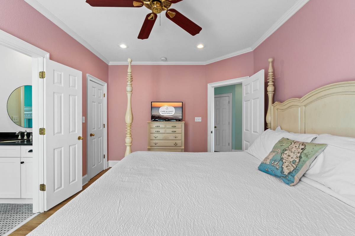 Drift off in your charming pink bedroom with elegant four-poster bed, ceiling fan, and thoughtful touches like bedside TV entertainment.