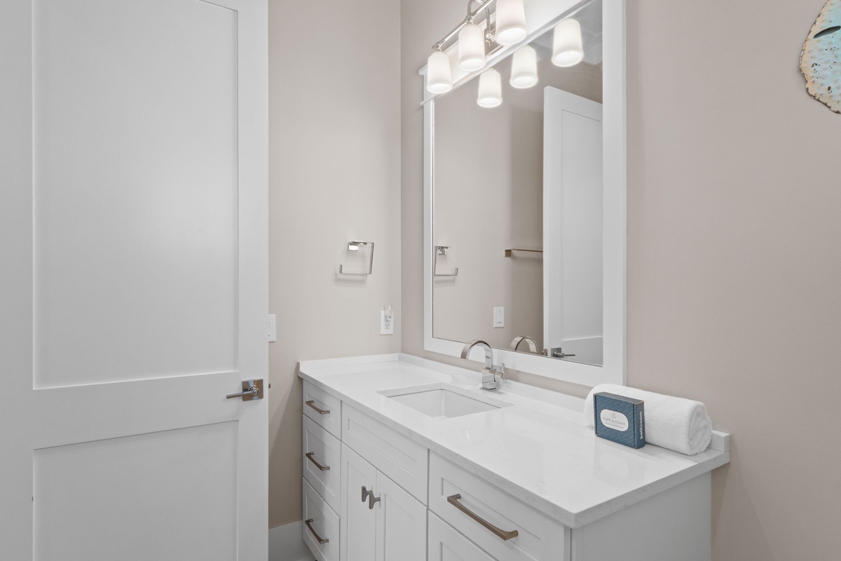Step into your pristine bathroom where sleek white cabinetry and modern fixtures create a spa-like retreat. Fresh towels await your arrival after a refreshing shower.