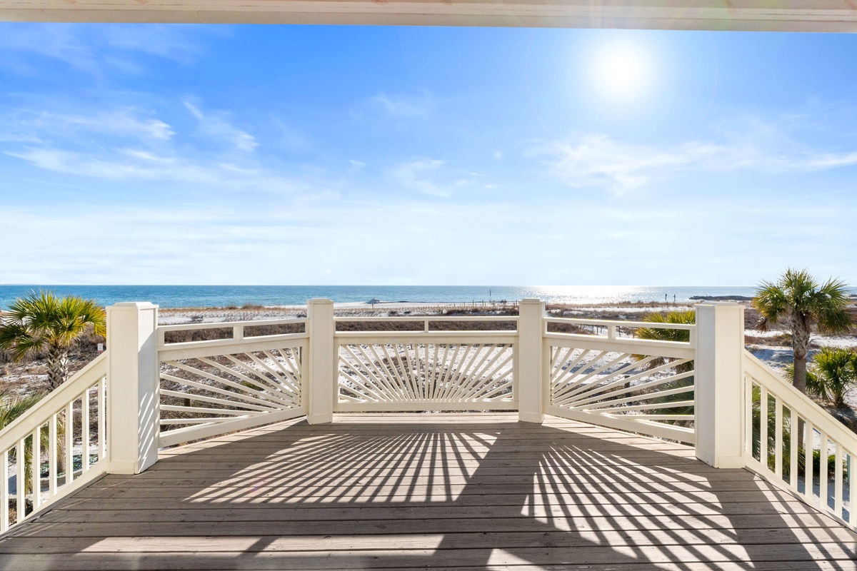 Pristine beachfront deck offering unobstructed ocean views with elegant railings and coastal charm.