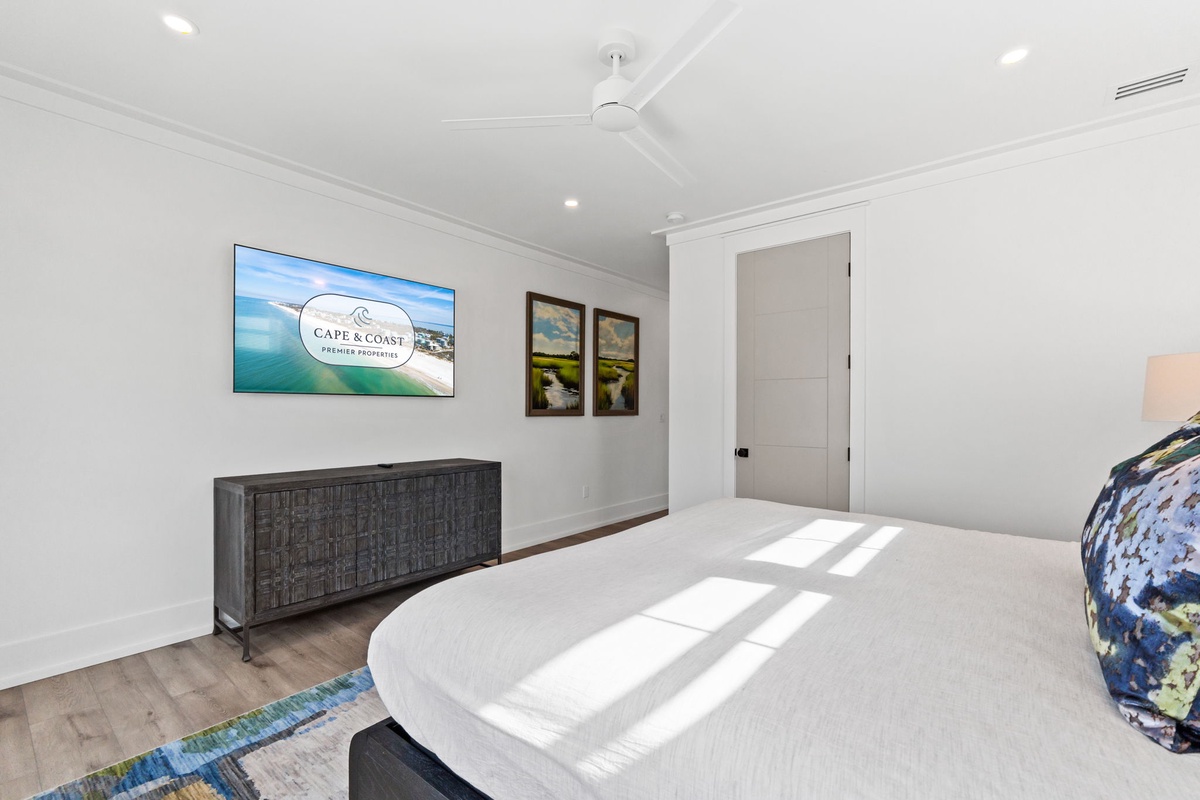 Wake up refreshed in your bright, modern bedroom featuring a smart TV and stylish furnishings for ultimate comfort.