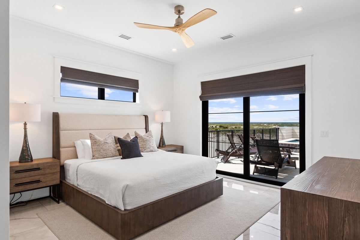 Your spacious bedroom features a plush king bed, modern ceiling fan, and private balcony overlooking stunning water views—perfect for serene mornings and peaceful evenings.