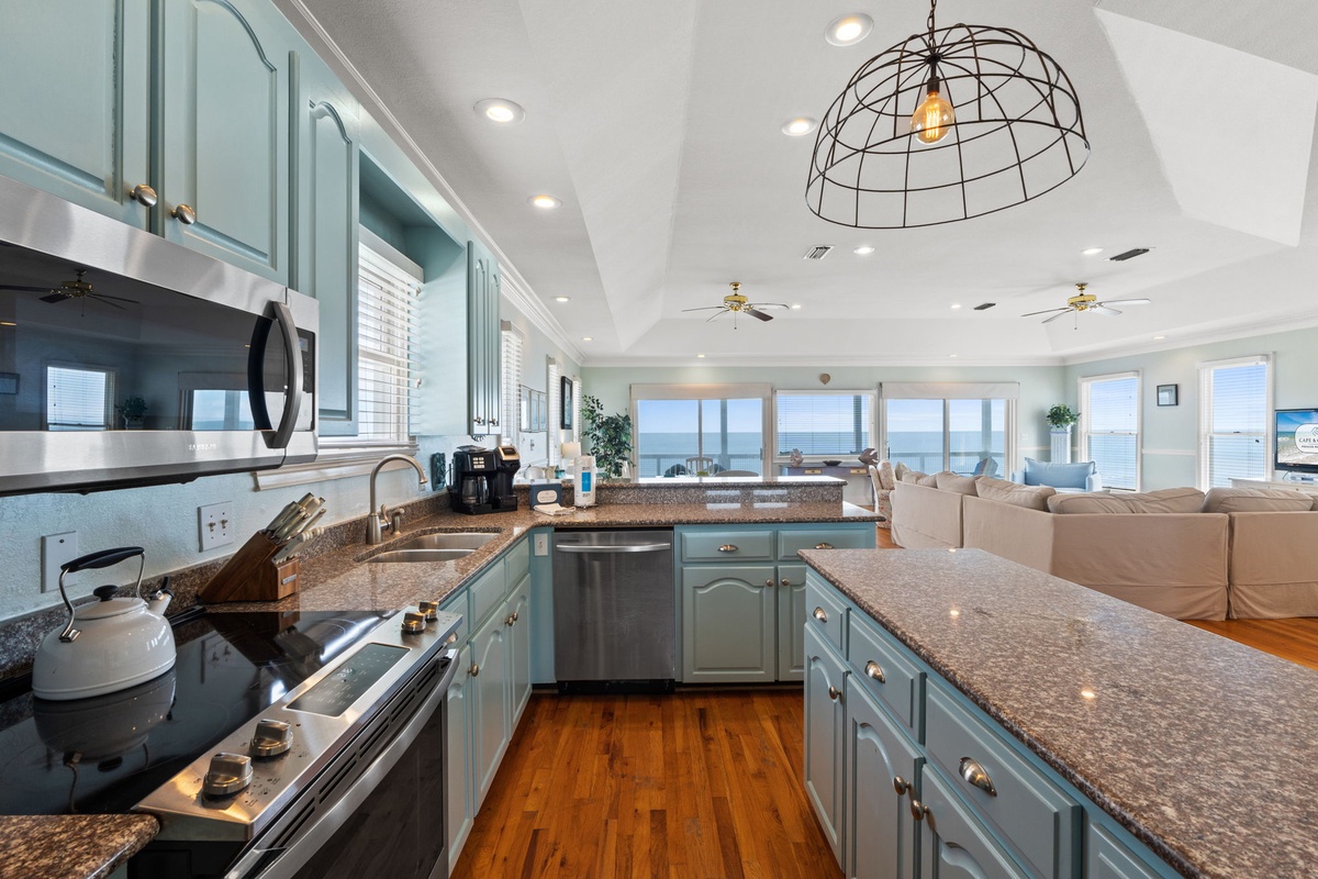 Your spacious gourmet kitchen welcomes you with granite counters and stunning ocean views through floor-to-ceiling windows.