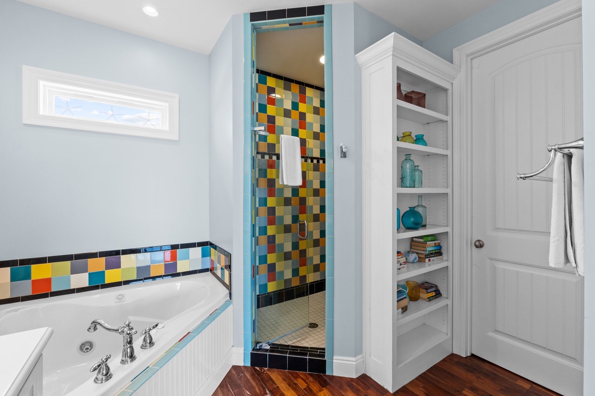 Your spa-like bathroom features a soaking tub with vibrant mosaic tile accents and a spacious tiled shower—perfect for unwinding after a day of adventure.