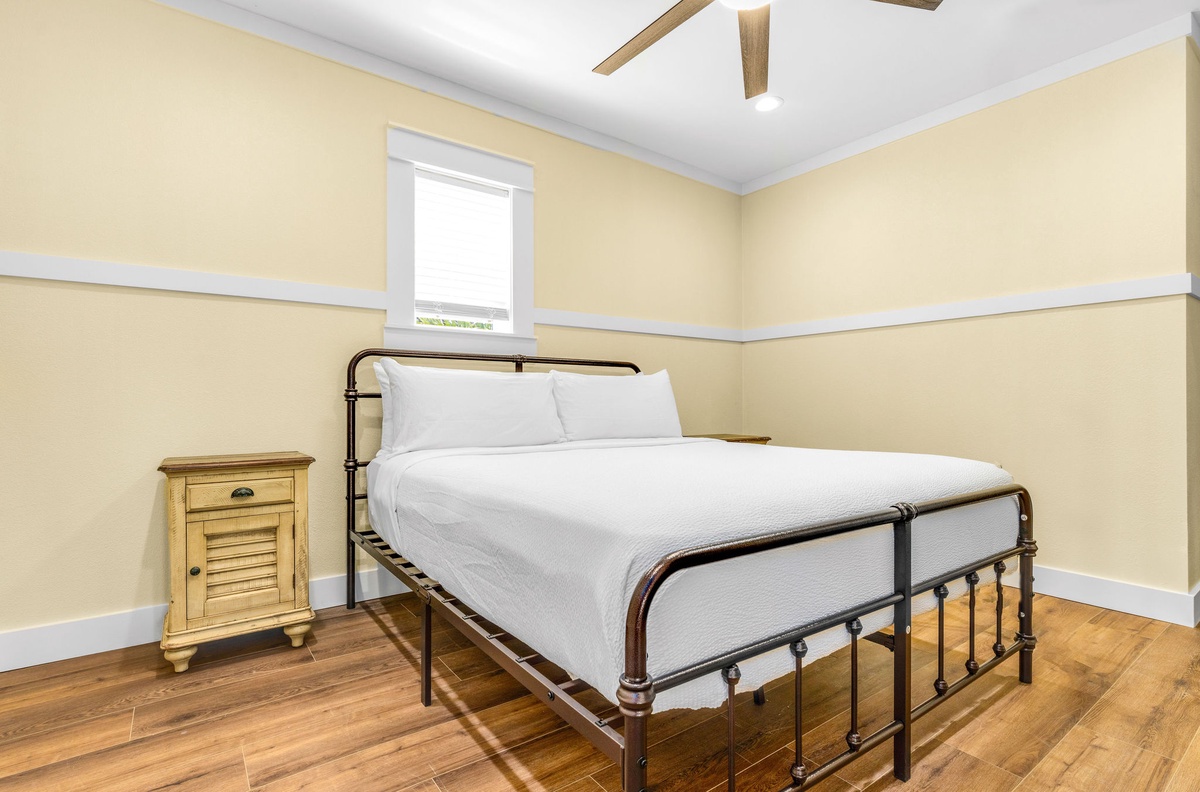 Sink into crisp white linens on your vintage iron bed, with warm wood floors and exposed beams creating a cozy retreat.
