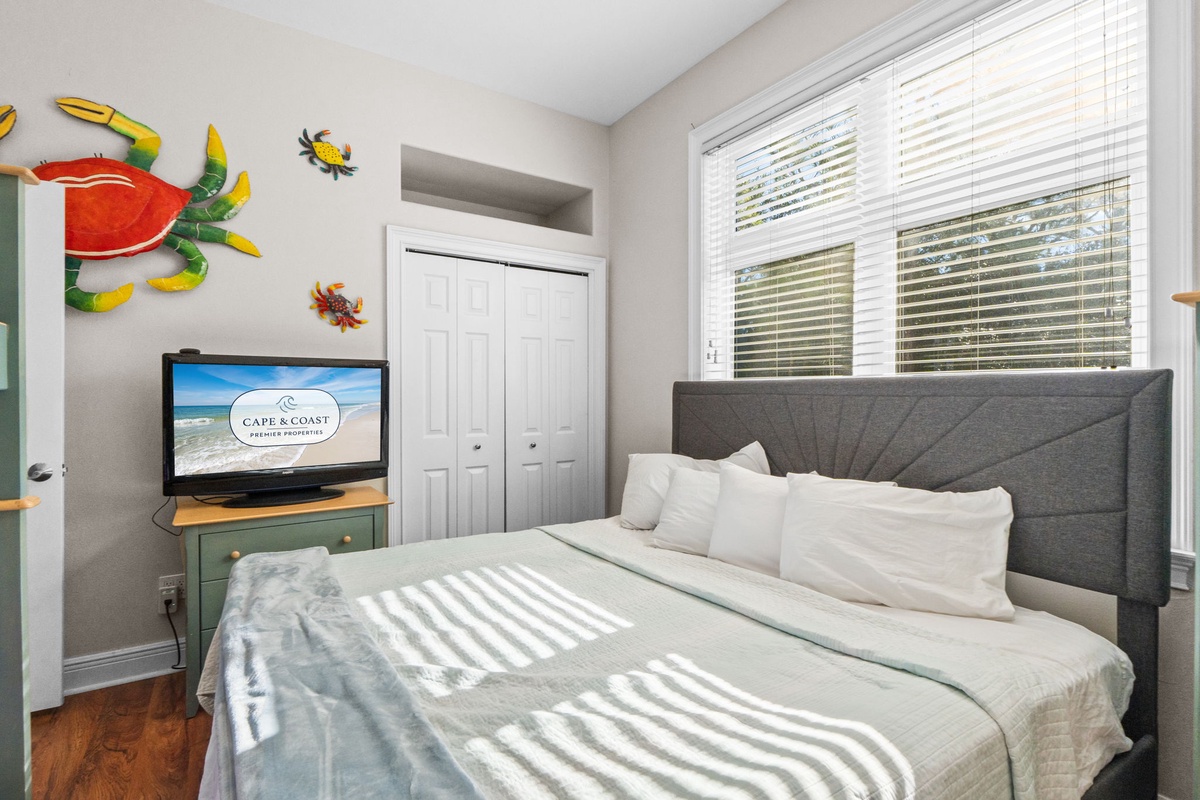 Wake up to sunlight streaming through your windows in this cozy bedroom with whimsical sea-themed decor and your own TV for relaxing mornings.